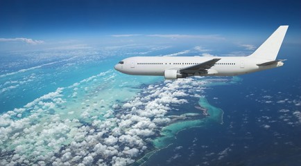Airliner over exotic island - obrazy, fototapety, plakaty