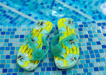 sandals flipflop slippers on the blue coast of pool