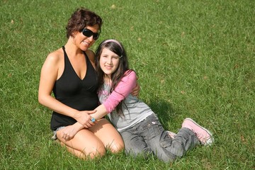 mother with her teen daughter on the grass