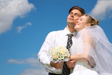 newlywed with bouquet against sky