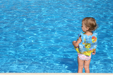 Fototapeta na wymiar little girl near the pool