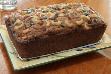 banana bread loaf topped with glazed fruit and nuts 