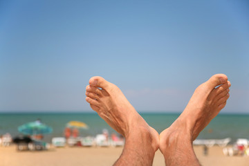 men's foots against beach