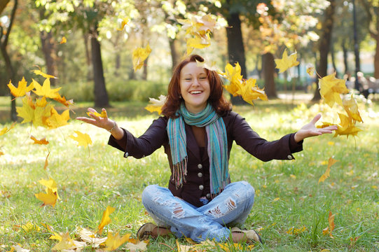 Young Girl Throwing Autumn Leaves