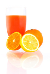 Oranges, piece of lemon and glass of juice