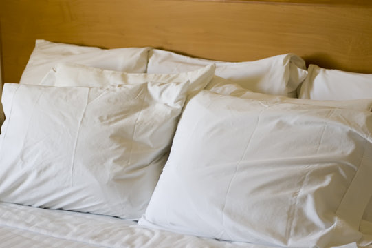 seven pillows with white pillowcases