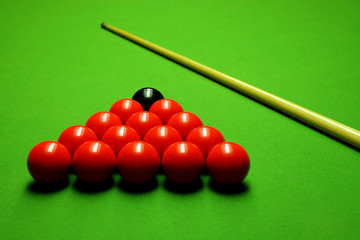 Cue stick and snooker balls over green surface