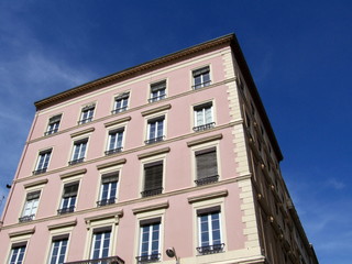 Fototapeta na wymiar Różowy budynek i śmietana, błękitne niebo. Lyon. Francja.