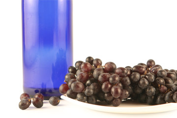Bottle of wine and grapes  isolated on white