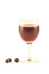 Grapes and a glass with red wine isolated on white.