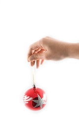 Girl holding a christmas ball with fingers over white background