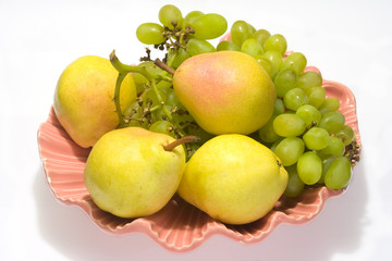 pears and grapes in pink vase with white background