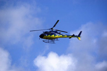 Fototapeta na wymiar ¯ółto-niebieskie Helicoper w niebie. Widok z boku