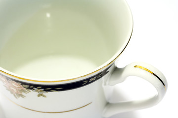 close-up of porcelain tea cup and saucer with white background