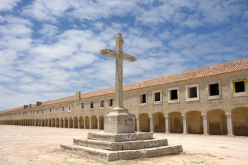 Cross with old monastery