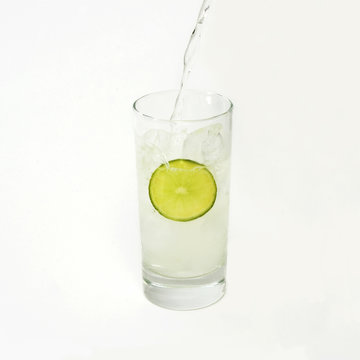 Pouring fresh lemonade on a glass - isolated