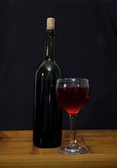 Red wine - bottle and glass isolated on black