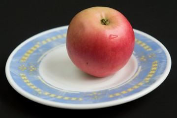 Red apple on a saucer