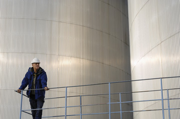 engineer in front of oil tanks