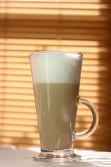 Cafe Latte in a tall glass and sunny light, soft focus