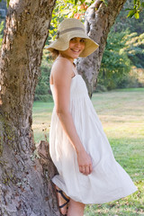 Woman with hat in the orchard