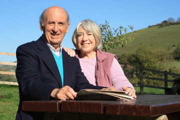  Mature couple on a bench with map and countryside