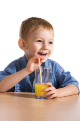 Laughing boy drinking orange juice