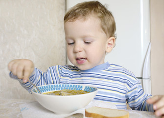 little boy eating soup
