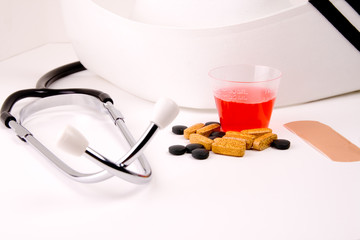 Medication in cup with stethoscope