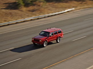 Fototapeta na wymiar Panning Red vehicle on highway