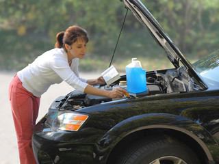 attractive woman trying to repair the car