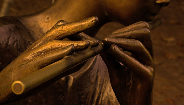 statua di ragazzino che suona il flauto