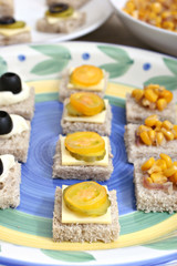 Obraz na płótnie Canvas Fruit and vegetable canapés on a white ceramic plate