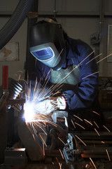 Welding welding a metal part in an industrial environment - obrazy, fototapety, plakaty