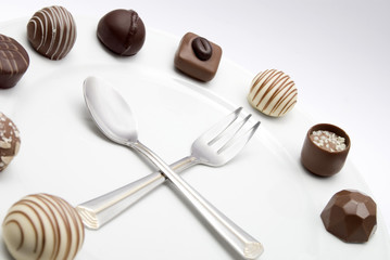 Chocolate clock with spoon and fork as clock hands