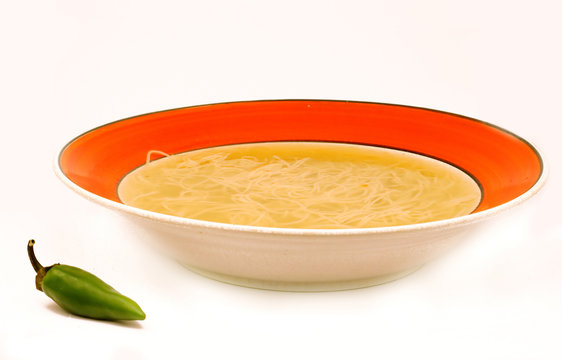 Traditional chicken soup with green pepper on white background