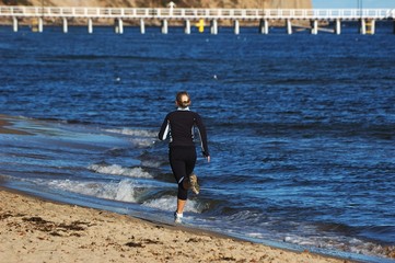 Young woman ruuning on the beach