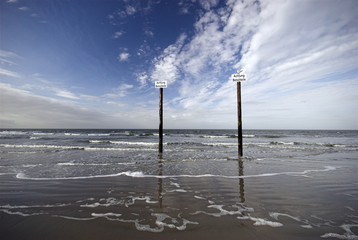 Beautiful North Sea landscape with wooden post warning 