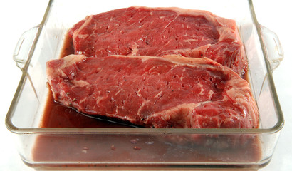marinating New York strip steaks