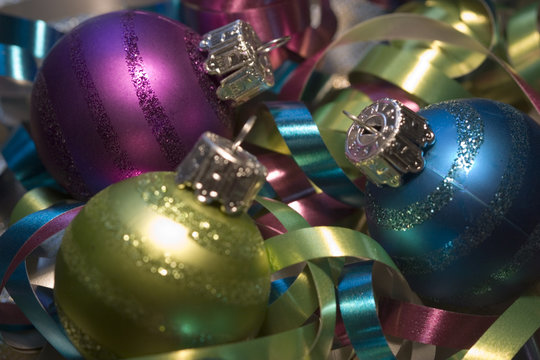 Three pretty Christmas ornaments and colorful ribbons