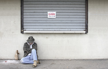 Obraz na płótnie Canvas Homeless Man By a Bankrupt Business