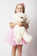 Fototapeta premium Nice young girl in pink on light background with teddy bear