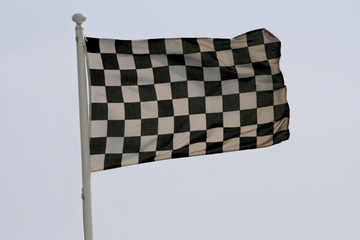 checkered race flag flapping in the sky - Powered by Adobe