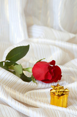 Fototapeta na wymiar Rose and jewelry on bed