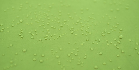 Fototapeta na wymiar Małe krople na zielonym tle