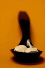 Pills in a black plastic spoon