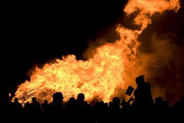 Fototapeta na wymiar Sylwetka tłumie przed dużym ognisku w nocy ognisko