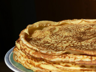 Mehrere Pfannkuchen auf einem Teller, Hintergrund schwarz
