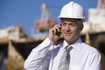 Engineer talking on cellphone in harbor