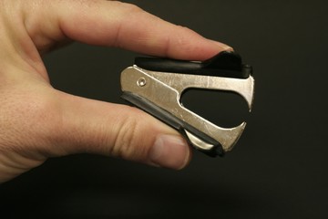 Man holding staple remover in fingers